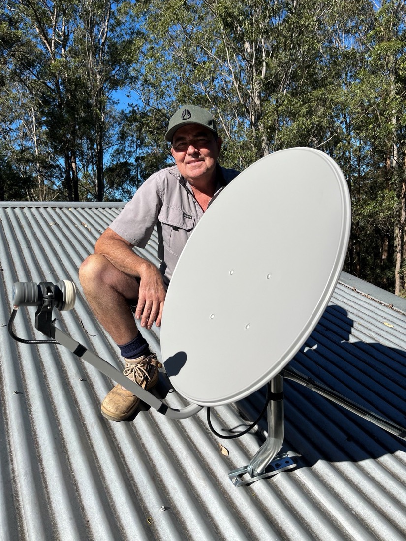 Nic from Orara TV Solutions installing a satellite dish on a Coffs Coast roof